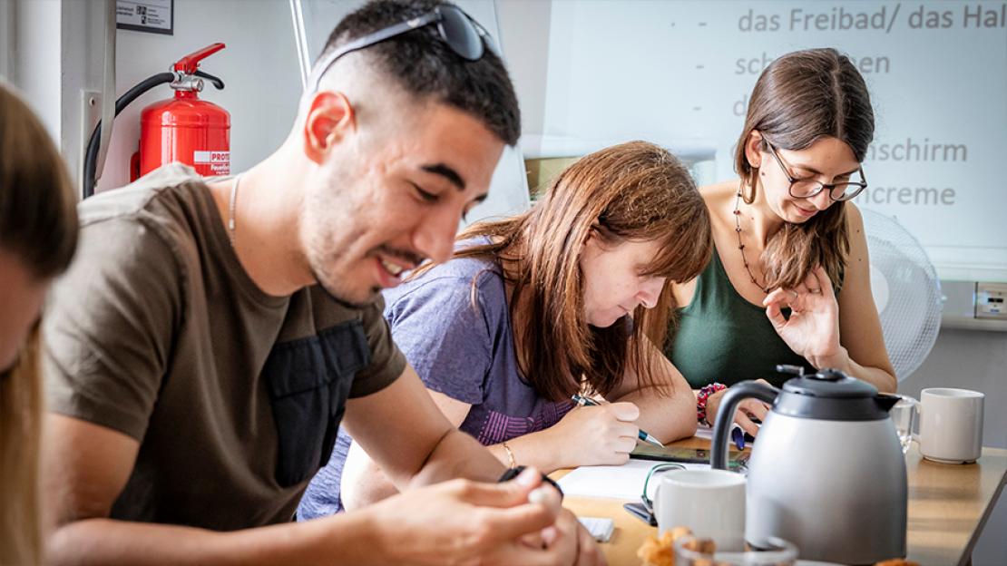 Motiv des "Vielfalt bewegt Frankfurt"-Kalenders für April 2024: Jugendliche an einem Tisch beim Deutschlernen im Sprachcafé des Vereins Abá.