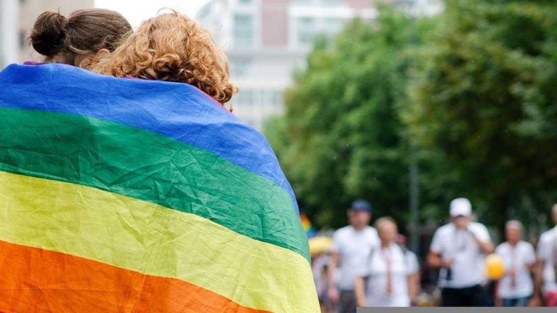 Zwei junge Frauen in eine Regenbogenflagge gehüllt auf der Frankfurter Zeil